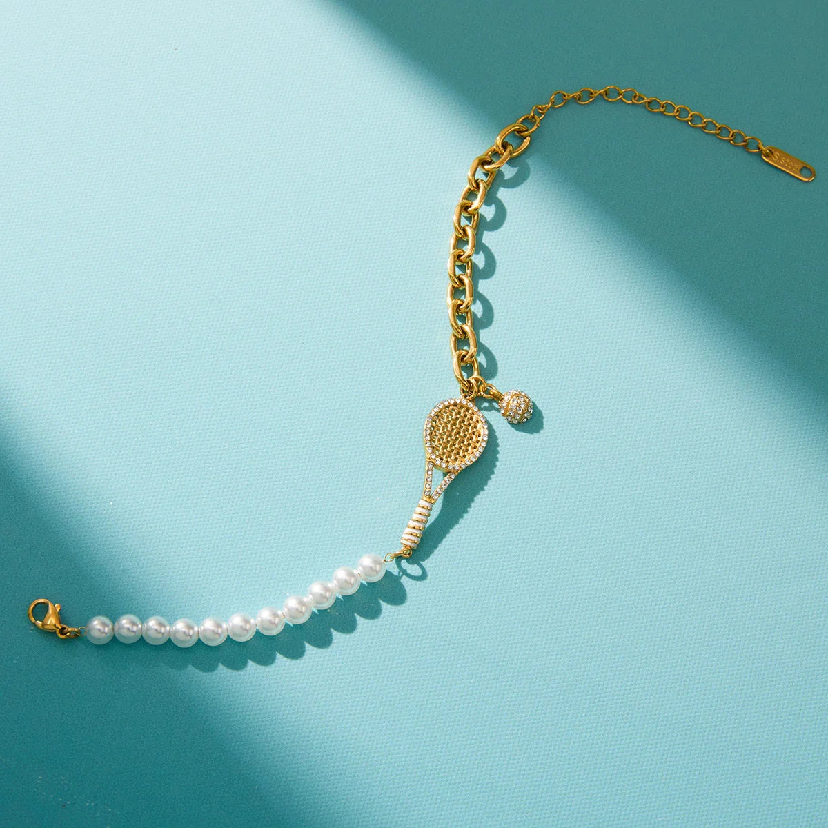 Pulseira de aço inoxidável banhada a ouro 18K com corrente assimétrica de imitação de pérolas e zircônia, modelo raquete de tênis, para mulheres.